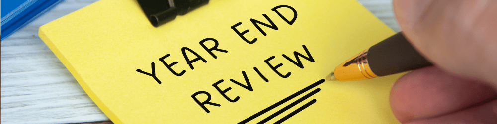 End of year review written on a yellow paper note